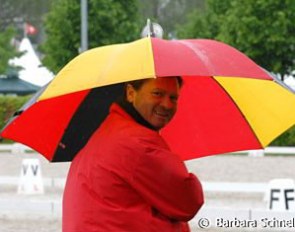 German Chef d'Equipe Holger Schmezer feeling very patriotic. Red coat and black, red and yellow umbrella: completely in the German colours.