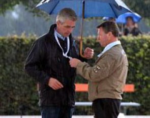 While Holger Schmezer did have his striking black-red-golden umbrella with him while the sun was shining, he left it in the car just before it started to pour. Junior riders' trainer Hans-Heinrich Meyer zu Strohen helps him out.