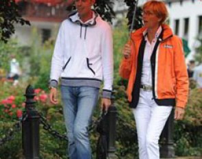 Hans Peter Minderhoud (coach of Brecht d'Hoore) and Tineke Bartels (Dutch chef d'equipe) share an umbrella