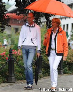 Hans Peter Minderhoud (coach of Brecht d'Hoore) and Tineke Bartels (Dutch chef d'equipe) share an umbrella