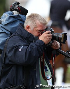 Belgian photographer Dirk Caremans taking photos of the riders, trainers and fans celebrating in the warm up