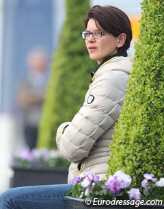 Florine Kienbaum's trainer Caro Roos watches her student's horse Doktor Schiwago in the warm-up