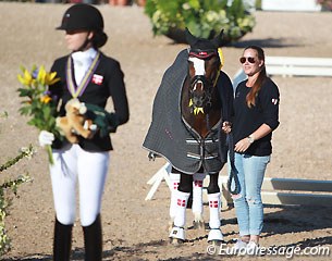 Sara van Deurs Petersen's proud coach, Cathrine Dufour (European Young Riders Champion 2012 and 2013) holding Farbenfroh during the prize giving
