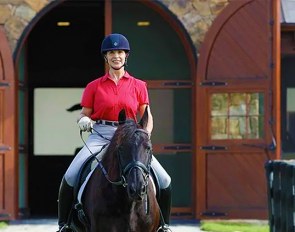 Jane Savoie on her Friesian Grand Prix stallion Menno, joined by dog Indy :: Photo © Rhett Savoie