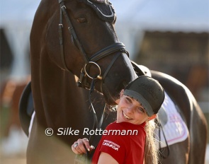 Roberta Sheffield’s groom Alyssa Carter cuddling with Dr. House Jr. (by Dr. Watson-Rotspon) in the tender evening sunshine at the 2024 CPEDI Mannheim :: Photo © Silke Rottermann