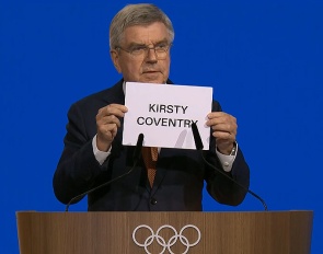 IOC president Thomas Bach shows the name of the winner of the secret ballot at the 144th IOC Session being held in Costa Navarino