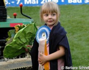 Ann Kathrin Linsenhoff's daughter Marie with her brother's winner's ribbon.