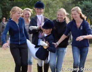 Louisa Luttgen gets dragged off for her winner's baptism