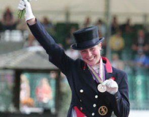 Laura almost blushes when she shows her bronze medal to the photographers