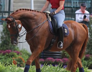 Isabell Werth walks Warum Nicht FRH round the arena and smiles at a volunteer