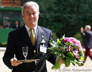Each dressage rider gets half a glass of champagne from Michael Ripploh after their ride