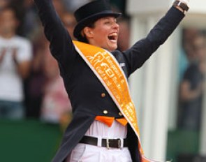 An ecstatic Adelinde straddles the podium and raises her fist in victory