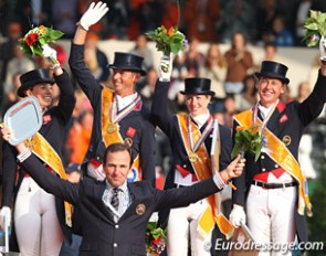 The British team celebrates gold. Chef d'equipe Will Connell holds up his silver plaque
