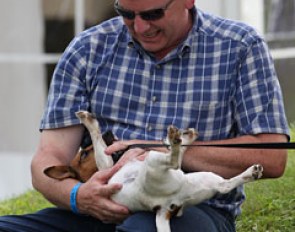 Belgian young rider Saidja Brison's father Philip plays with their dog