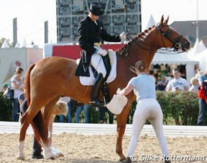 Talk about having two top grooms: Matthias Bouten on Krack while Madeleine Winter-Schulze and Isabell Werth prepare the horse
