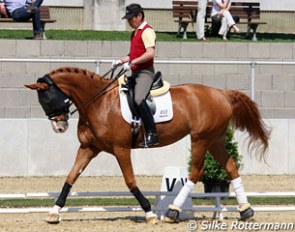 Japanese Hiroshi Hoketsu riding Whisper who wears a fly mask for protection from the bugs
