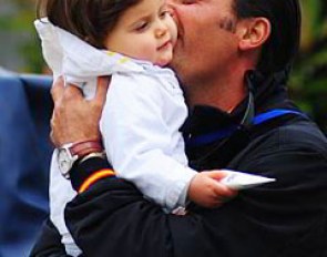 Jose Antonio Garcia Mena, who has been helping Isabell Werth to put the piaffe on her horses, cuddles with his child