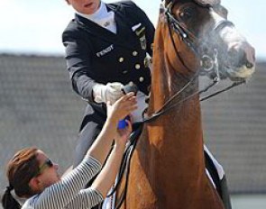 Isabell Werth's groom prepares Bella Rose with a final bit of fly spray before the mare enters the ring