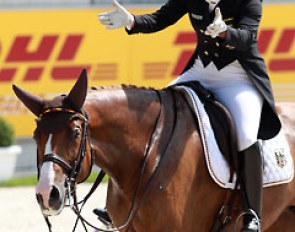 Isabell Werth points at her horse Bella Rose for her greatness