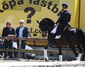 Trainer Sjef Janssen and co-owner Paul Schockemohle are watching Matthias Rath warm up Totilas