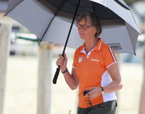 Dutch team trainer Tineke Bartels uses an umbrella to protect herself from the sun