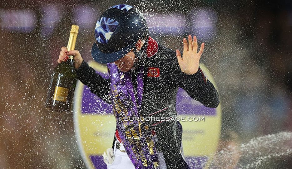 Lottie Fry getting a champagne shower after winning freestyle gold at the 2022 World Championships Dressage :: Photo © Astrid Appels
