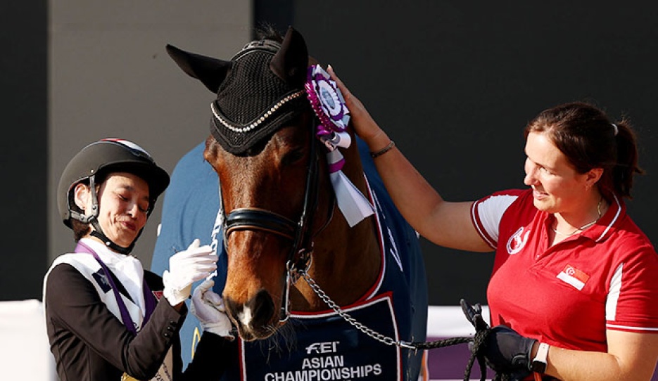 Laurentia Tan of Singapore celebrates with Hickstead after winning gold during the para dressage freestyle individual championship :: Photo © FEI/Yong Teck Lim
