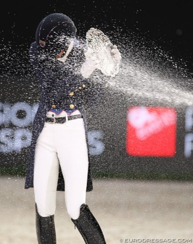 Laura Graves gets a champagne shower, fending off the spray with her trophy