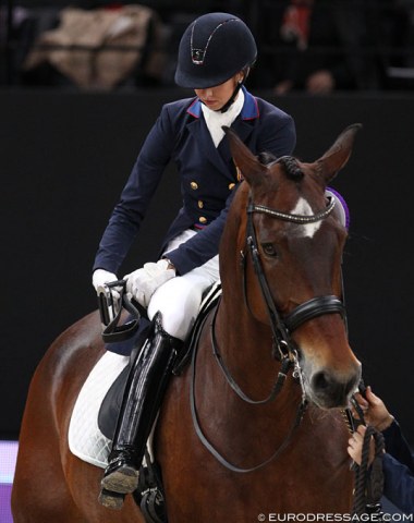 First things first: Laura Graves pulls up her stirrups before dismounting for the prize giving ceremony