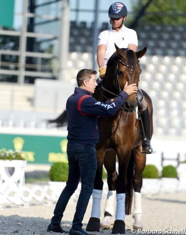 U.S. team trainer Robert Dover fixes Rosamunde's bridle