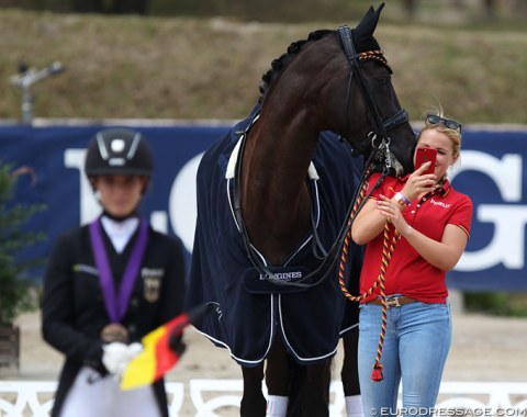 Coach Anna Abbelen holds Summer Rose and makes her student Romy Allard's podium time a social media moment