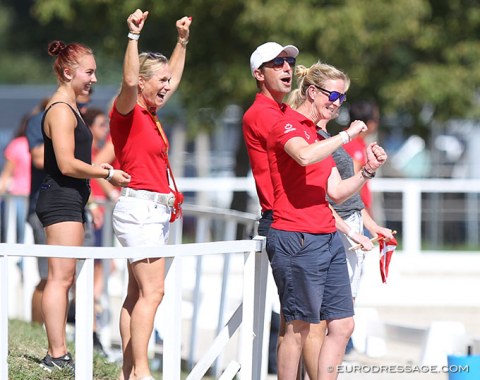 The Danish team trainers and captain celebrate when they hear the winning score