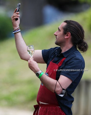 The guy from the cheese and salami place taking a selfie with a glass of champagne