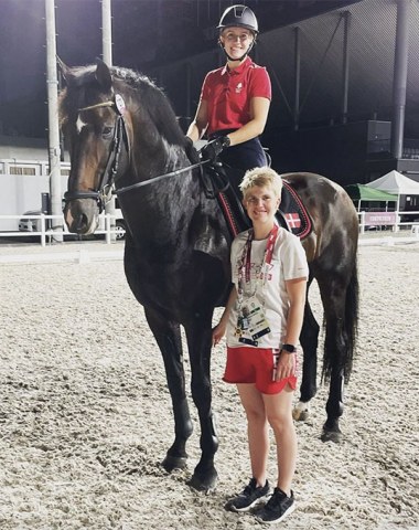 Nanna Skodborg Merrald on Blue Hors Zack flanked by the groom