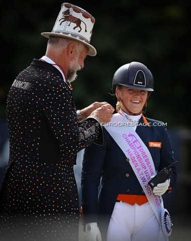 Ringmaster Pedro Cebulka helps Jessica Poelman to pin down her medallist's sash