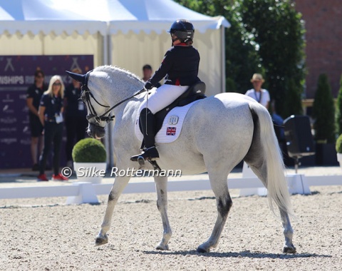 The Connemara x ISH-crossbred Strong Beau and Gabby Blake from Great Britain perform while the British support team follows their every step in the tent behind the arena.