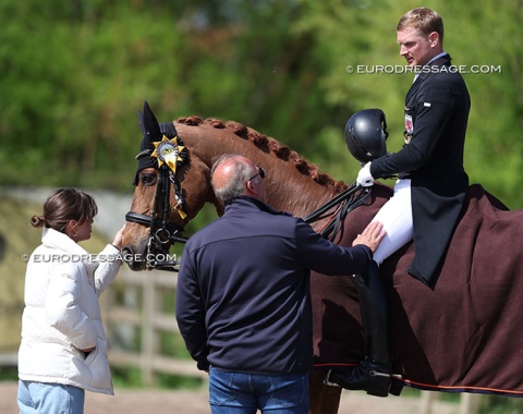 Coach Norbert van Laak gives student Nicolas Wagner a pat on the leg