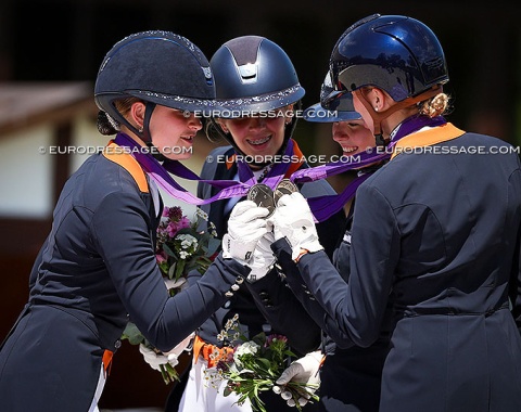 The Dutch young riders do a "cheers" with their silver medals