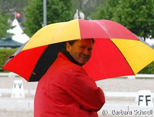 German Chef d'Equipe Holger Schmezer feeling very patriotic. Red coat and black, red and yellow umbrella: completely in the German colours.