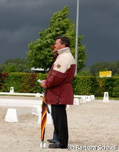 The Special day was one with torrential down pours. Holger Schmezer is watching Linsenhoff warm up but the thunder storm is approaching rapidly