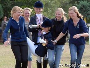 Louisa Luttgen gets dragged off for her winner's baptism