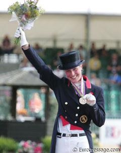 Laura almost blushes when she shows her bronze medal to the photographers