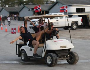 Norwegian rider Lillan Jebsen having fun. Team trainer Bjarne Nielsen behind the steering wheel of the golf cart