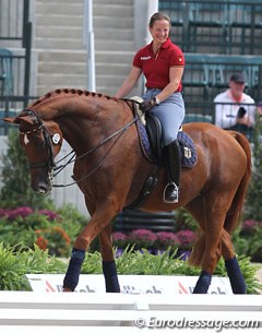 Isabell Werth walks Warum Nicht FRH round the arena and smiles at a volunteer