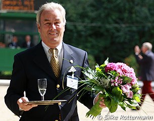Each dressage rider gets half a glass of champagne from Michael Ripploh after their ride