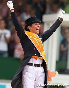 An ecstatic Adelinde straddles the podium and raises her fist in victory