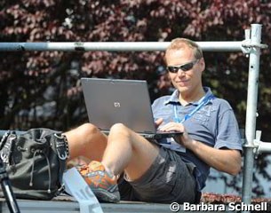 Danish journalist Thomas Bach Jensen working on his laptop outside in the sunshine