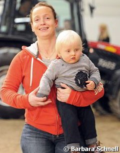 Isabell Werth carrying her son Frederik