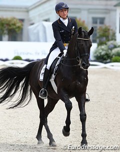 Ingrid Klimke pats Dresden Mann after he settles down from spooking in the corner due to horses passing by. The Dresemann offspring was very tense at the start of his test but slowly improved