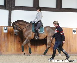 Sanneke and Favourit in the indoor school, flanked by father Sven Rothenberger